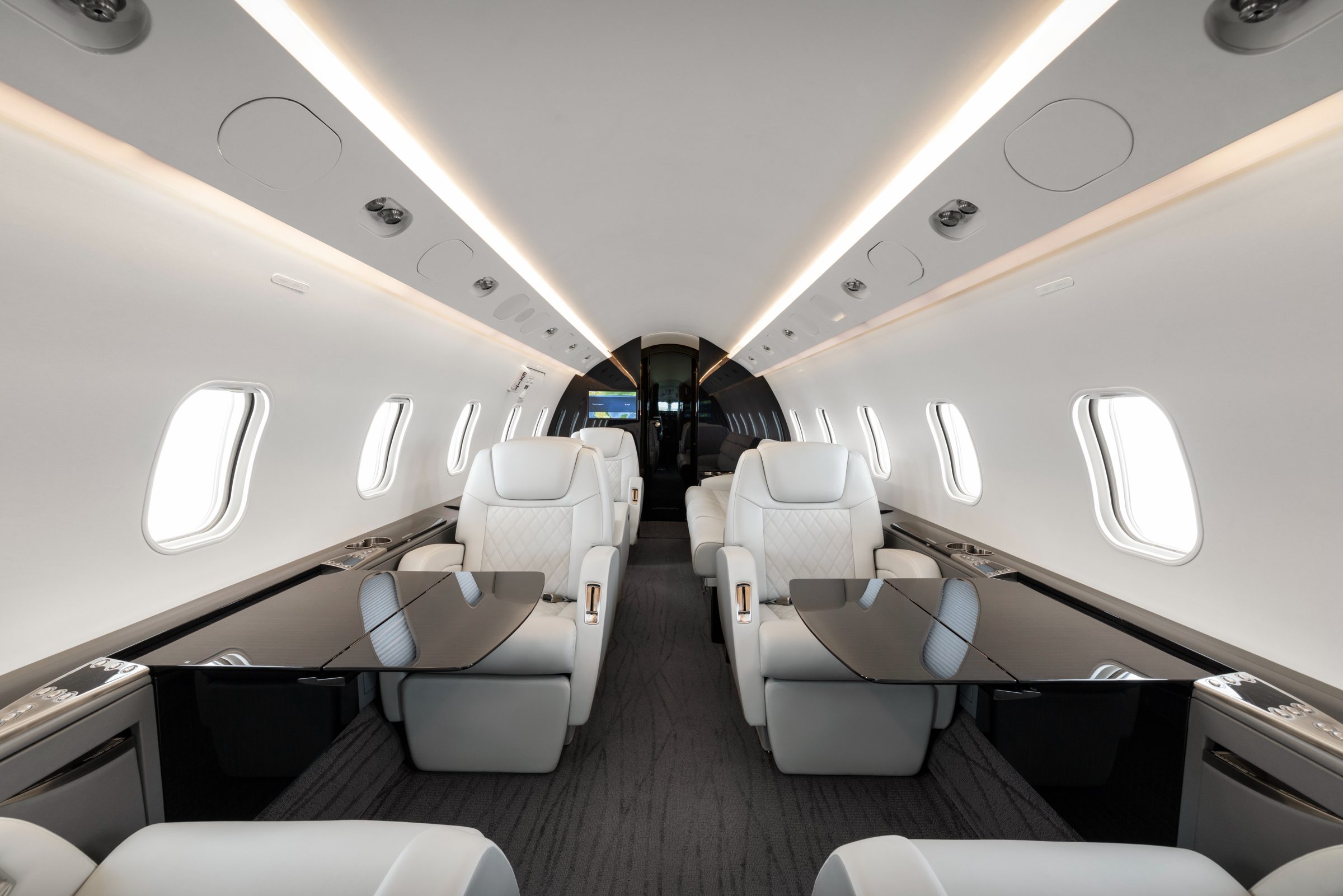 Club seats with conference tables deployed on both sides of the aisle
