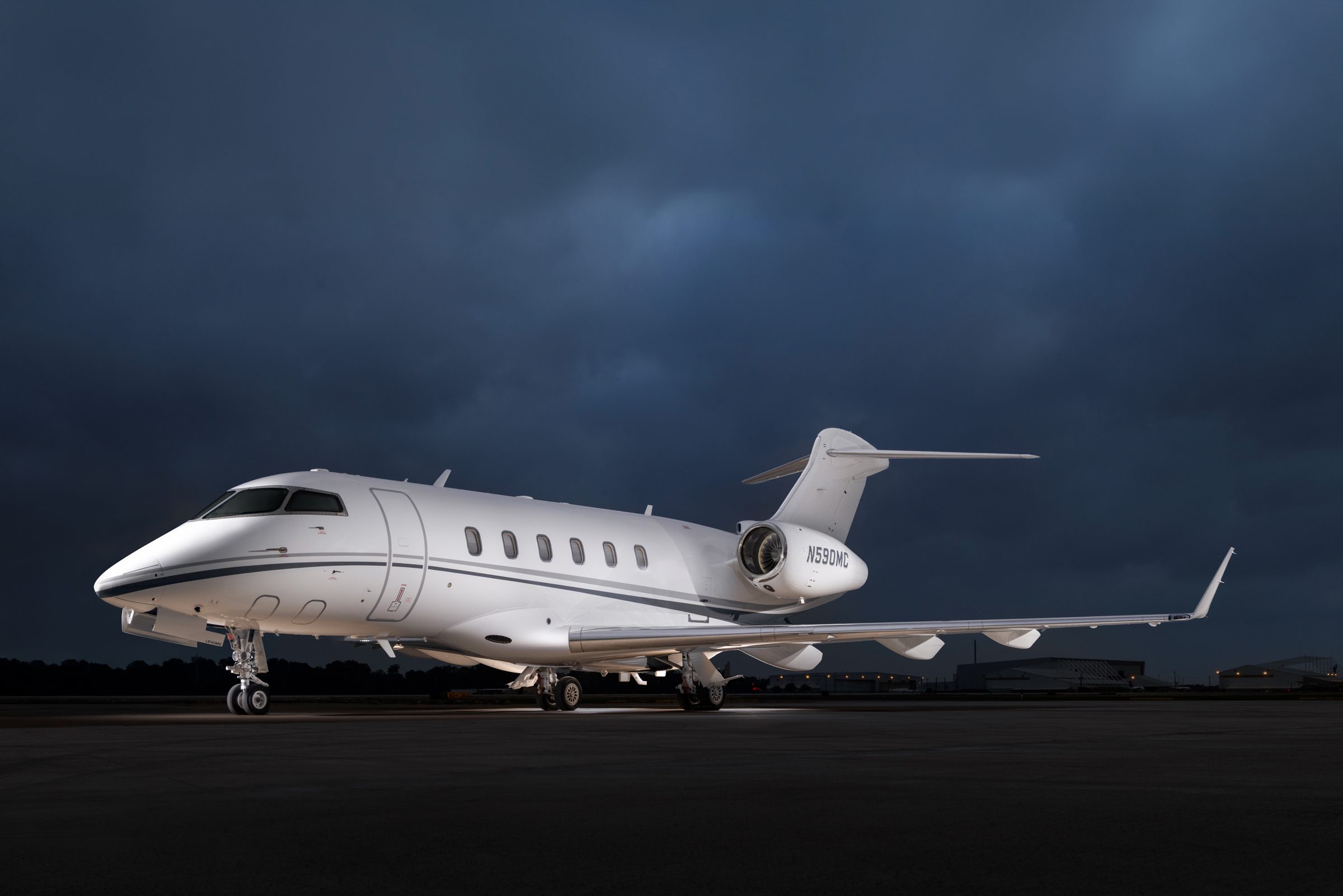 Challenger 300 N590MC parked on a ramp under a stormy dusk sky